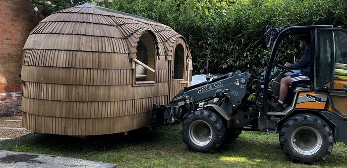 Operated telehandler placing a garden building